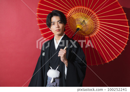 一個穿著帶徽章的袴的男人,一把日本傘 一個穿著帶徽章的袴的男人,一把日本傘 100252241