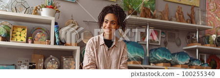Smiling woman is packing handmade candles for selling in own home decor studio Smiling woman is packing handmade candles for selling in own home decor studio 100255340