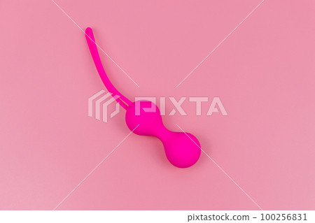 Ben Wa balls or Geisha balls on pink background. Pink double vaginal balls 100256831