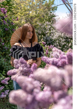 portrait of young woman with long hair outdoors in blooming lilac garden portrait of young woman with long hair outdoors in blooming lilac garden 100256878