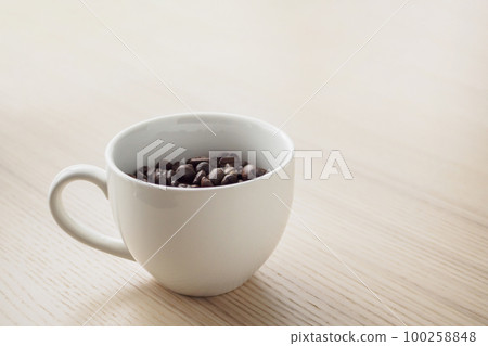 fresh roasted coffee beans in white cup on wood table fresh roasted coffee beans in white cup on wood table 100258848