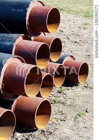 Metal pipes for water pipes folded on the grass Metal pipes for water pipes folded on the grass 100260171