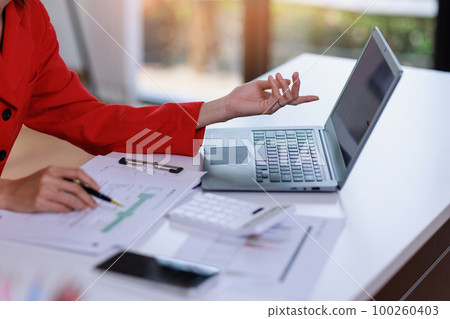 Concept of business invesment or woman working,Closeup businesswoman checking her invesment plan with analyzing document and business investment graph data by using calculator and computer laptop 100260403