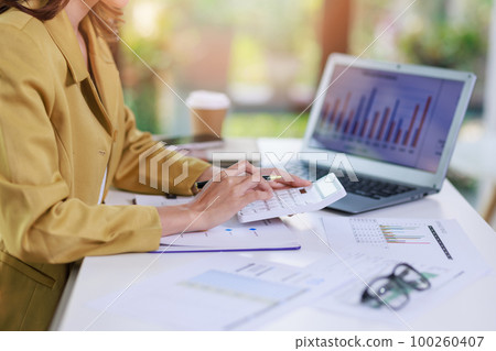 Concept of business invesment or woman working,Closeup businesswoman checking her invesment plan with analyzing document and business investment graph data by using calculator and computer laptop Concept of business invesment or woman working,Closeup businesswoman checking her invesment plan with analyzing document and business investment graph data by using calculator and computer laptop 100260407