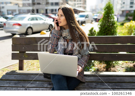 young woman freelancer working with laptop on the street young woman freelancer working with laptop on the street 100261346