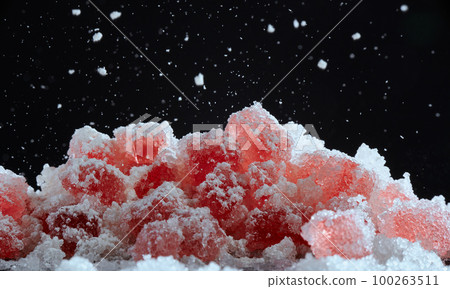 Strawberry red marmalade jelly candy's covered with powder sugar on black background. Photo with copy space. The concept of Christmas sweets. 100263511