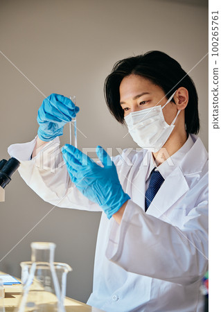一個穿白大褂的年輕人在做實驗 100265761