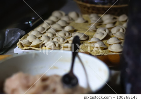 Raw homemade meat dumplings with onions. russian pelmeni on the dark lifestyle background. Meat dumplings, ravioli. Out of focus Raw homemade meat dumplings with onions. russian pelmeni on the dark lifestyle background. Meat dumplings, ravioli. Out of focus 100268143