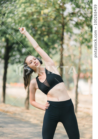 A sporty woman in sportswear is standing and stretching leg. Sport and recreation concept. 100268439
