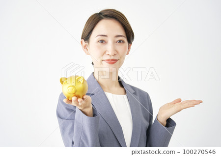 一位女商人拿著存錢罐,手掌向右指著白色背景 一位女商人拿著存錢罐,手掌向右指著白色背景 100270546