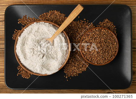 Buckwheat Flour Pile in Wood Bowl, Dry Buck Wheat Powder, Buckwheat Flour on Wooden Rustic Background Buckwheat Flour Pile in Wood Bowl, Dry Buck Wheat Powder, Buckwheat Flour on Wooden Rustic Background 100271365