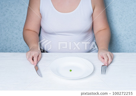 Cropped image of a girl eating peas. weight loss diet. Eating disorder. 100272255