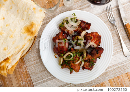 Barbecued pork shashlik with onion and herbs 100272260