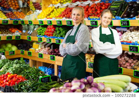 Girl helping her mother work as a salesman in a grocery store 100272288