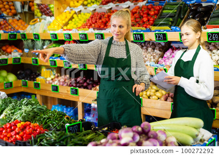 Woman grocery store owner giving instructions to young salesgirl 100272292