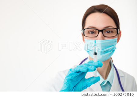 Siri Nurse holds a syringe in her hand, preparing for the introduction of a drug, vaccination concept. 100275010