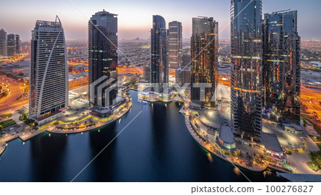 Tall residential buildings at JLT aerial night to day timelapse, part of the Dubai multi commodities centre mixed-use district. 100276827