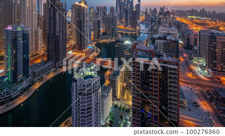 View of various skyscrapers in tallest recidential block in Dubai Marina aerial night to day timelapse 100276860