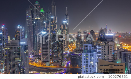 View of various skyscrapers in tallest recidential block in Dubai Marina aerial all night timelapse 100276861
