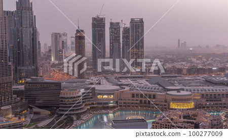 Dubai downtown with fountains and modern futuristic architecture aerial night to day timelapse 100277009