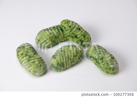Pile of green spinach gnocchi dough dumplings isolated over the white background Pile of green spinach gnocchi dough dumplings isolated over the white background 100277308