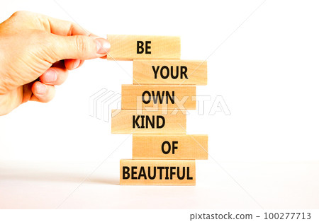 Be beautiful symbol. Concept words Be your own kind of beautiful on wooden blocks on a beautiful white table white background. Businessman hand. Business be your own kind of beautiful concept. 100277713