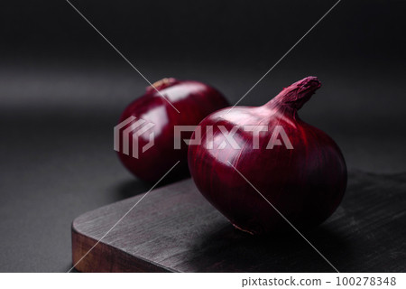 Fresh raw red onion on dark textured concrete background 100278348