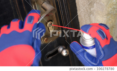 Door lock and handyman hands with spray balloon close up. 100278780