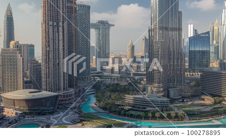 Skyscrapers rising above Dubai downtown timelapse, mall and fountain surrounded by modern buildings aerial top view 100278895