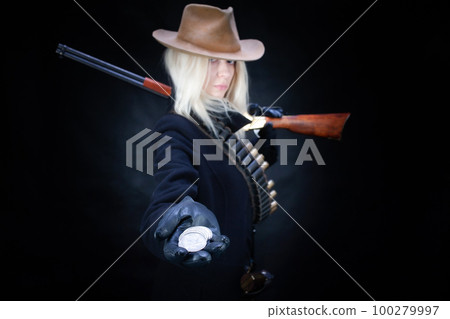 Old west blonde girl with silver dollars in hand and gun 100279997