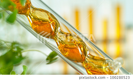 Getting essential oil from natural substances and flowers. Yellow oil flows in a spiral. Getting essential oil from natural substances and flowers. Yellow oil flows in a spiral. 100280523