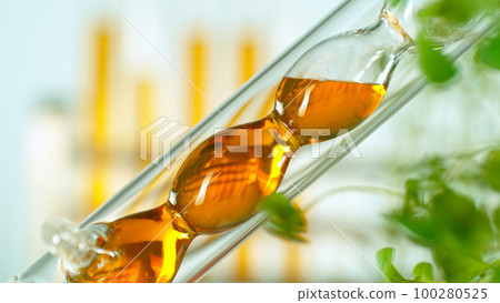 Getting essential oil from natural substances and flowers. Yellow oil flows in a spiral. Getting essential oil from natural substances and flowers. Yellow oil flows in a spiral. 100280525
