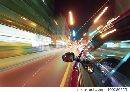 Long exposure of a speedy night drive in a big city 100280555