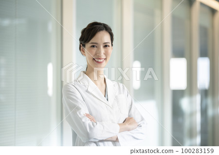 一位身穿白大衣的 30 多歲女性看著相機人像攝影合作“LINK FOREST” 100283159