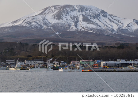 Shooting a scallop fishing boat returning to Sunahara fishing port in Morimachi, Hokkaido in early spring and the scenery of Mt. Sunahara in the remaining snow 100283612