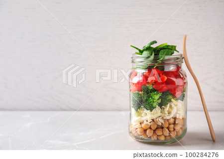 Healthy salad in glass jar on white table. Space for text Healthy salad in glass jar on white table. Space for text 100284276
