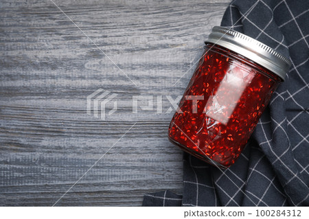 Homemade delicious raspberry jam on grey wooden table, flat lay. Space for text Homemade delicious raspberry jam on grey wooden table, flat lay. Space for text 100284312