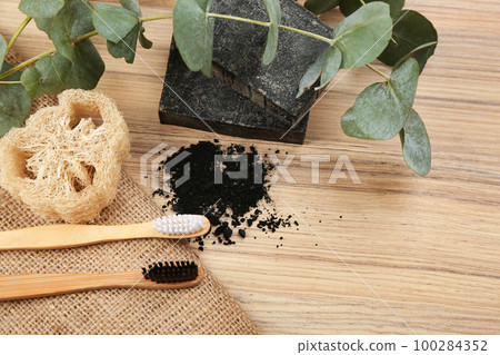 Flat lay composition with natural bamboo toothbrushes on wooden table 100284352