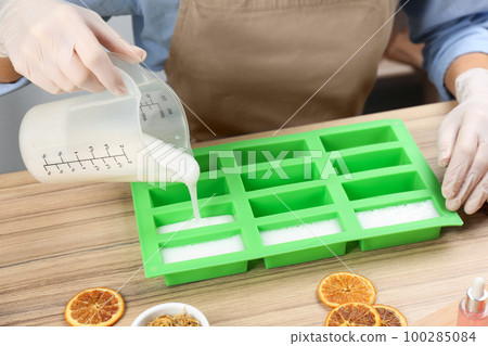 Woman making natural handmade soap at wooden table, closeup Woman making natural handmade soap at wooden table, closeup 100285084