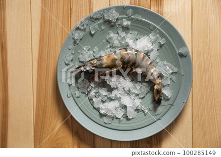 Fresh black tiger shrimp with ice on wooden table, top view Fresh black tiger shrimp with ice on wooden table, top view 100285149