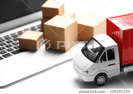 Toy truck near laptop on table. Logistics and wholesale concept 100285150