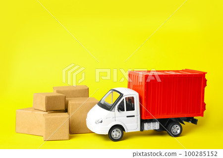 Toy truck with boxes on yellow background. Logistics and wholesale concept 100285152