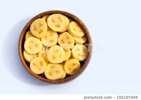 Banana slices in wooden bowl on white background Banana slices in wooden bowl on white background 100285949