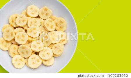 Banana slices isolated on green background 100285950