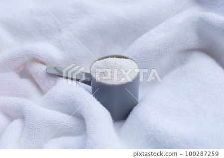 Detergent powder in measuring spoon on towel. Laundry concept. Detergent powder in measuring spoon on towel. Laundry concept. 100287259