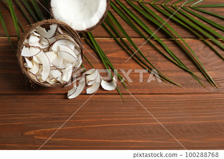 Tasty coconut chips on wooden table, above view Tasty coconut chips on wooden table, above view 100288768