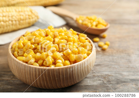 Delicious canned corn on wooden table, closeup Delicious canned corn on wooden table, closeup 100288786