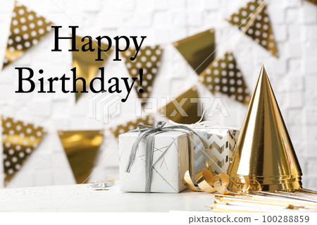Gifts, party cones and greeting HAPPY BIRTHDAY on blurred background Gifts, party cones and greeting HAPPY BIRTHDAY on blurred background 100288859