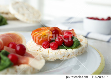 Puffed rice cakes with prosciutto, berries and basil on plate, closeup Puffed rice cakes with prosciutto, berries and basil on plate, closeup 100289096