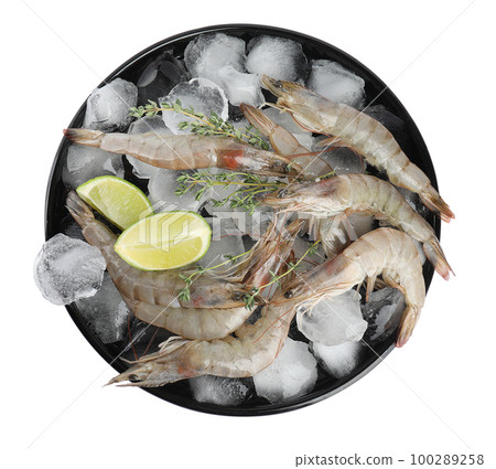 Plate with raw shrimps, lime slices, thyme and ice isolated on white, top view 100289258